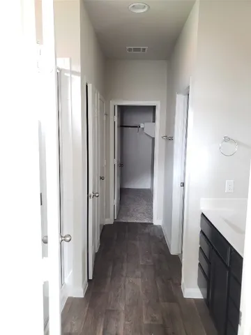 an empty room with closet and a hallway