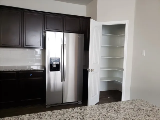 a view of an empty room with closet and wooden door