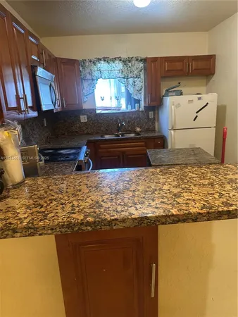a kitchen with stainless steel appliances granite countertop a sink stove and cabinets