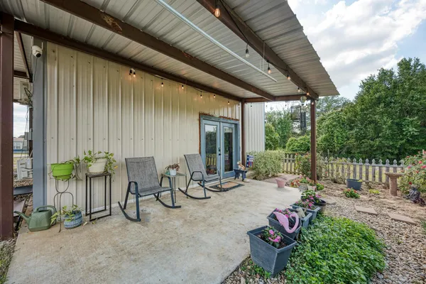 a view of a patio with table and chairs potted plants with wooden fence