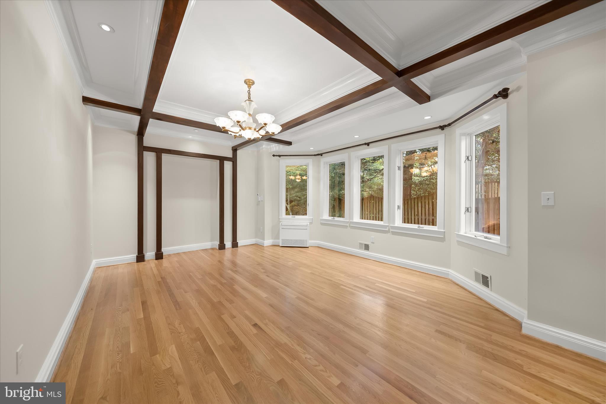 5104 Scarsdale Road Bethesda, MD 20816 - Photo 22 of 68 a view of an empty room with chandelier fan and wooden floor