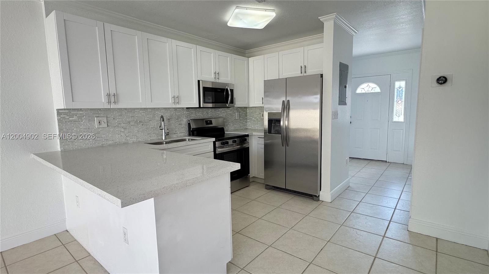 9465 Southwest 77th Court Miami, FL 33156 - Photo 11 of 25 a kitchen with stainless steel appliances granite countertop a refrigerator sink and microwave