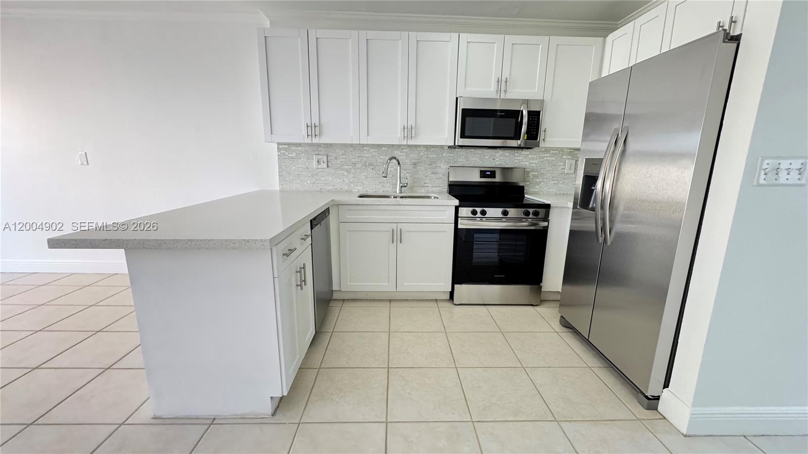 9465 Southwest 77th Court Miami, FL 33156 - Photo 13 of 25 a kitchen with a sink and a refrigerator