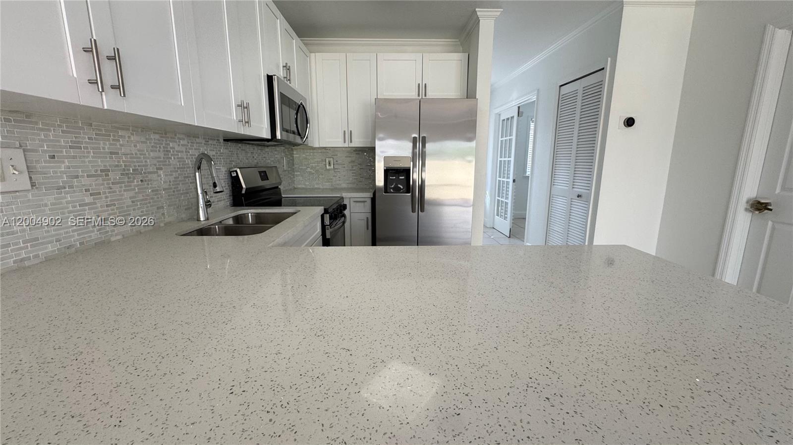9465 Southwest 77th Court Miami, FL 33156 - Photo 17 of 25 a kitchen with stainless steel appliances a sink a stove and a refrigerator
