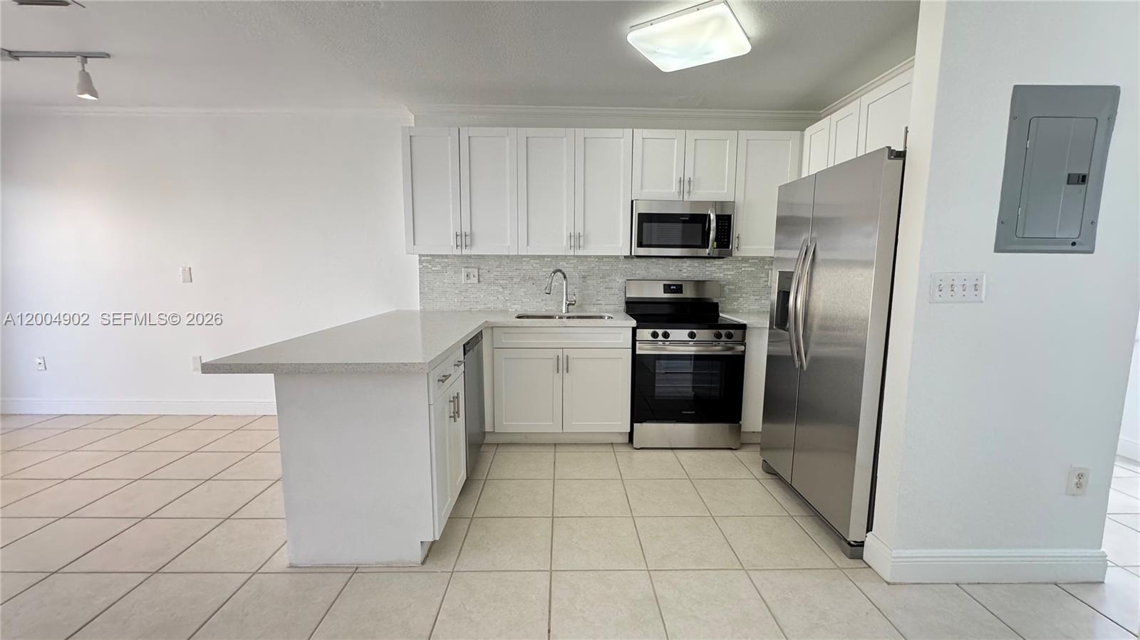 9465 Southwest 77th Court Miami, FL 33156 - Photo 2 of 25 a kitchen with stainless steel appliances cabinets a sink and a stove