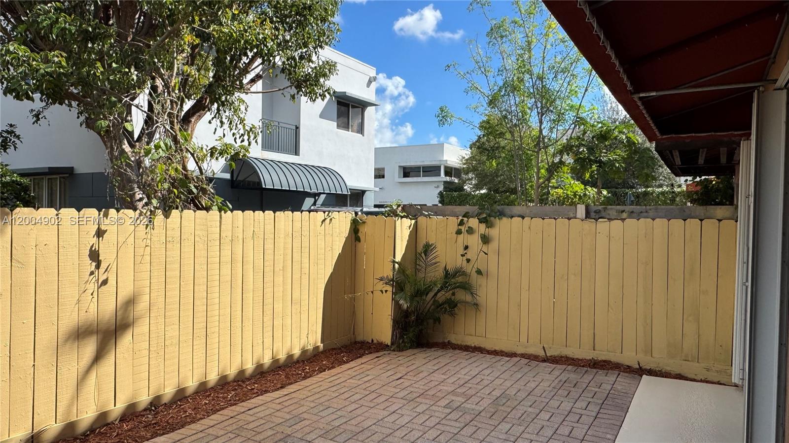 9465 Southwest 77th Court Miami, FL 33156 - Photo 22 of 25 a view of a house with a wooden fence