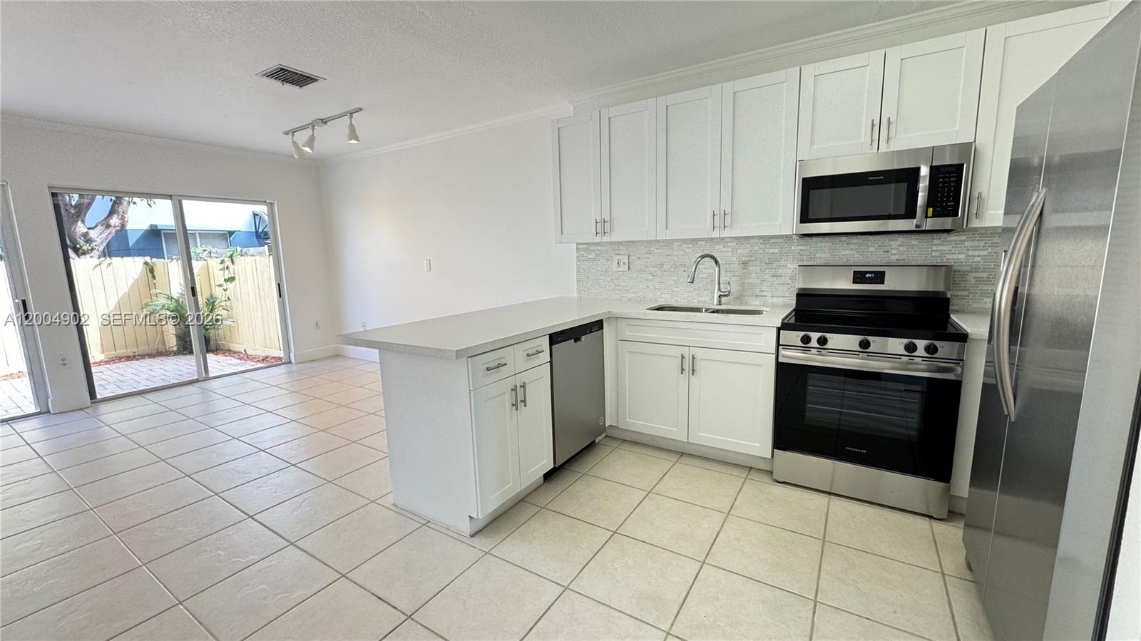 9465 Southwest 77th Court Miami, FL 33156 - Photo 3 of 25 a kitchen with a stove a sink and a microwave
