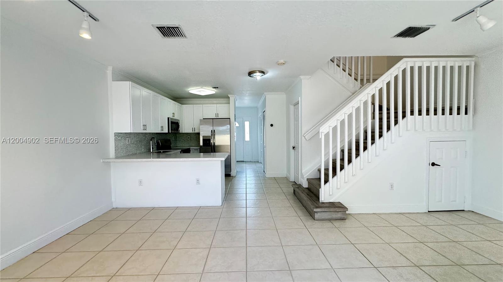 9465 Southwest 77th Court Miami, FL 33156 - Photo 6 of 25 a kitchen with white cabinets and appliances
