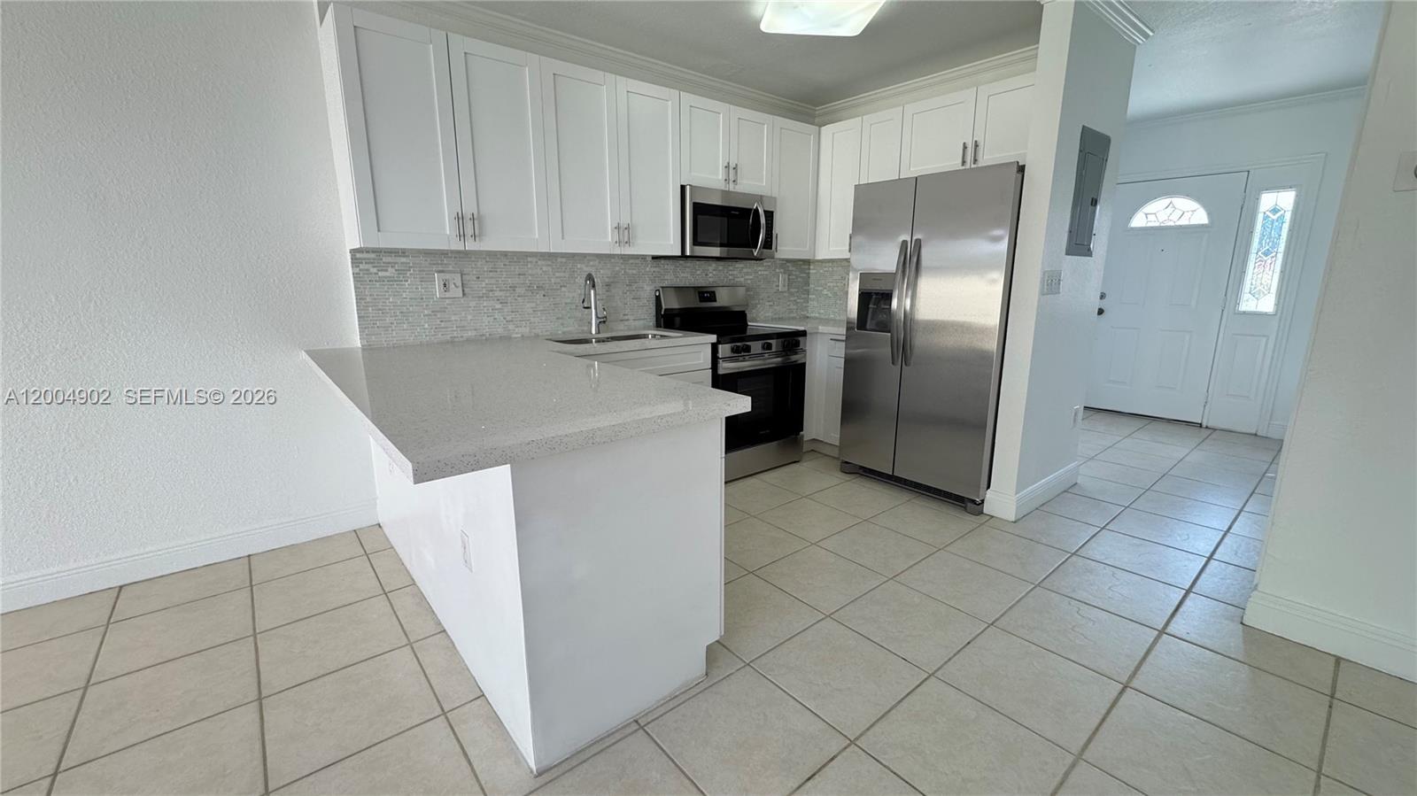 9465 Southwest 77th Court Miami, FL 33156 - Photo 10 of 25 a kitchen with stainless steel appliances a refrigerator sink and microwave