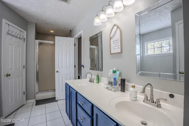a spacious bathroom with a double vanity sink mirror and a shower