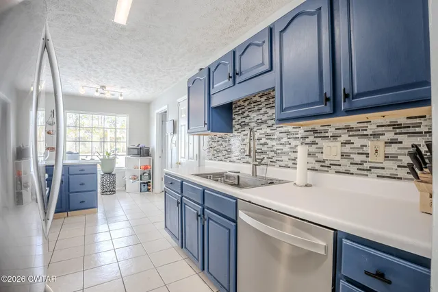 a kitchen with stainless steel appliances a sink stove and cabinets