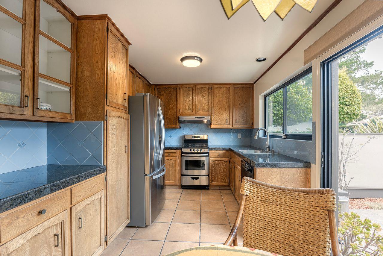 4 Country Club Gate, Unit 2 Pacific Grove, CA 93950 - Photo 3 of 11 a kitchen with granite countertop a refrigerator and a stove top oven