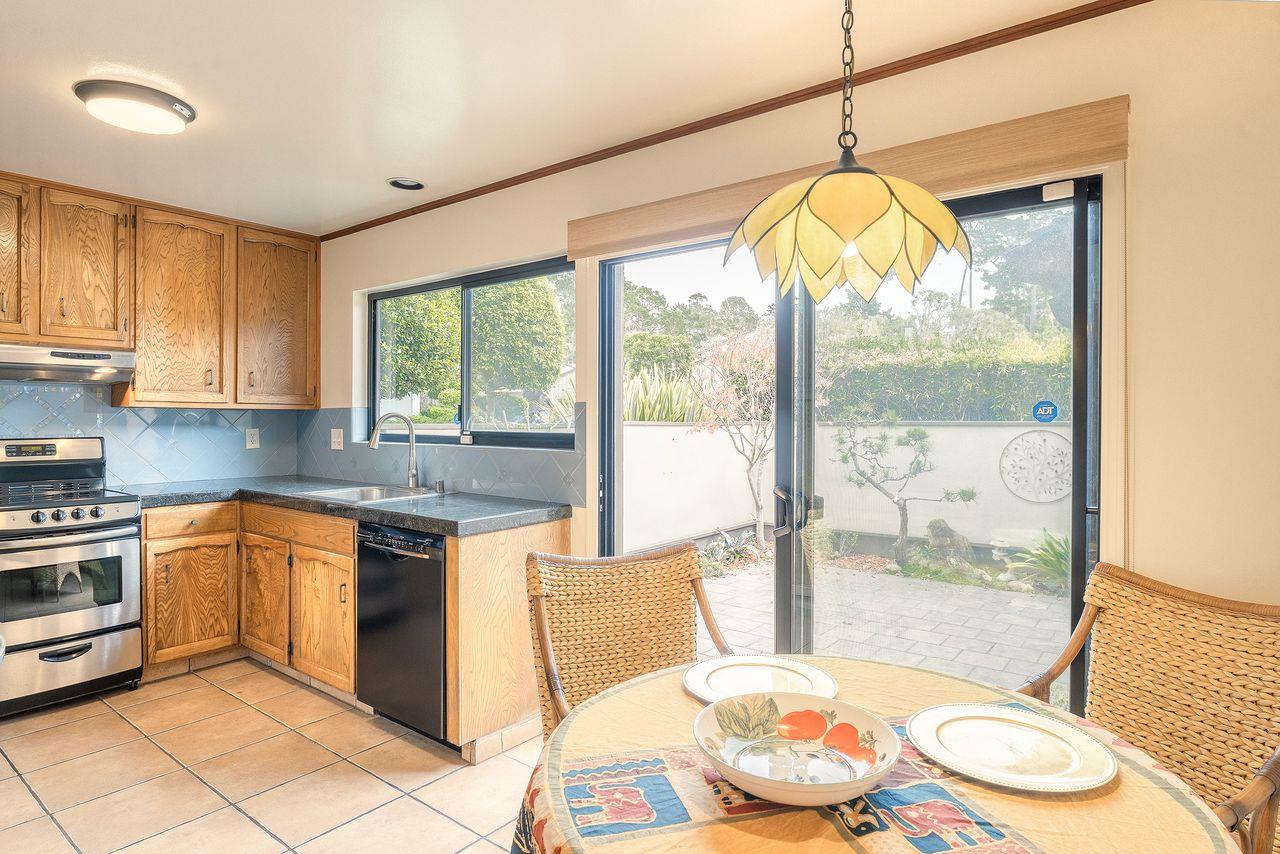 4 Country Club Gate, Unit 2 Pacific Grove, CA 93950 - Photo 4 of 11 a kitchen with stainless steel appliances granite countertop a stove a sink a refrigerator a dining table and chairs with wooden floor