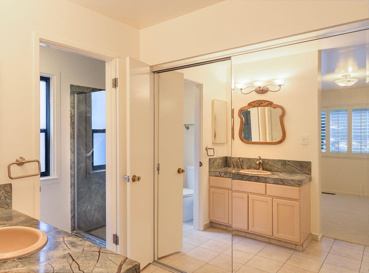 4 Country Club Gate, Unit 2 Pacific Grove, CA 93950 - Photo 8 of 11 a bathroom with a granite countertop sink a mirror and a shower