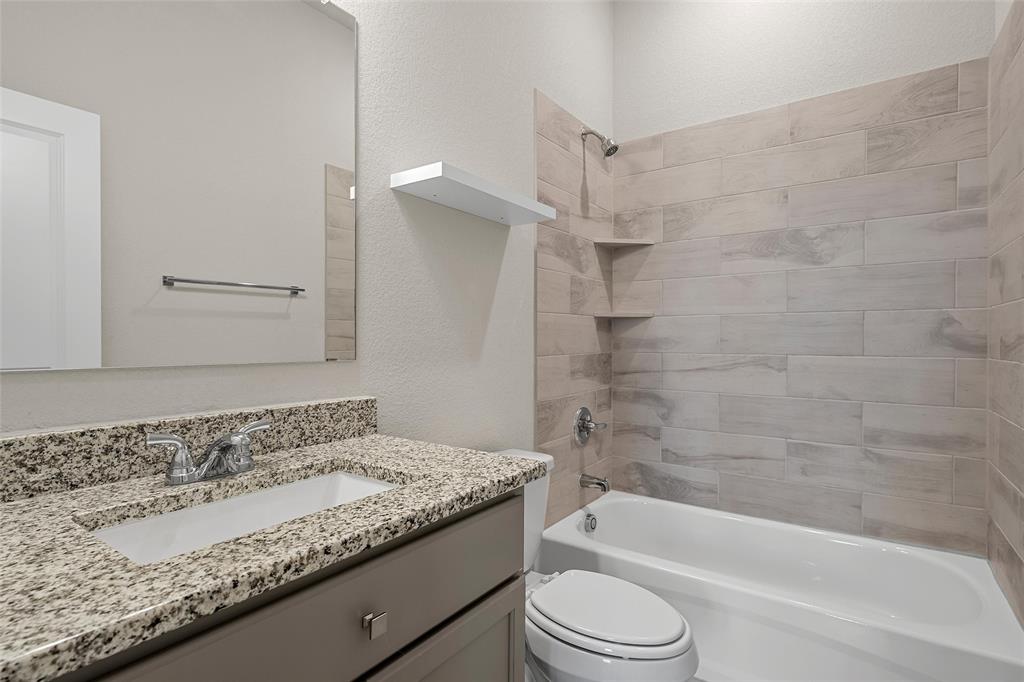 3224 Dottavio Road Lorena, TX 76655 - Photo 18 of 31 a bathroom with a granite countertop bathtub shower sink and toilet