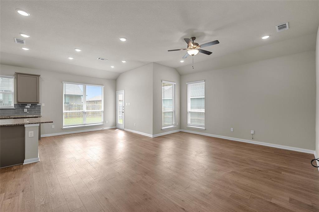 3224 Dottavio Road Lorena, TX 76655 - Photo 4 of 31 a view of an empty room with a kitchen and wooden floor