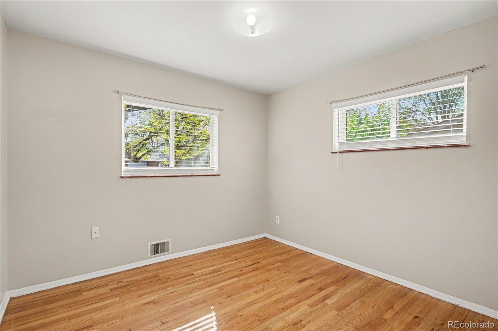 3217 South Stuart Street Denver, CO 80236 - Photo 14 of 29 a view of an empty room with wooden floor and a window