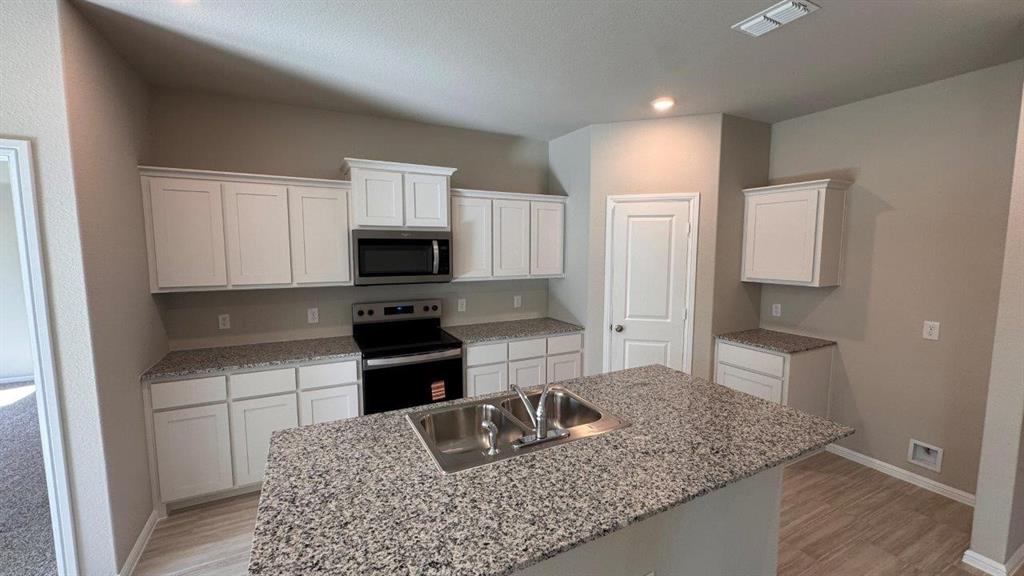 549 Marsh Street Cleburne, TX 76033 - Photo 2 of 20 a kitchen with a stove microwave and sink