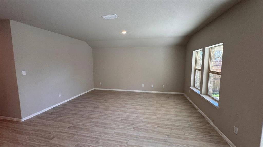 549 Marsh Street Cleburne, TX 76033 - Photo 6 of 20 a view of an empty room with wooden floor and a window