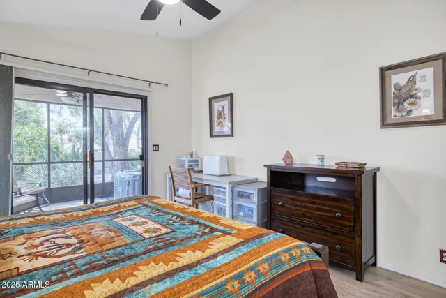 a living room with furniture a flat screen tv and a floor to ceiling window