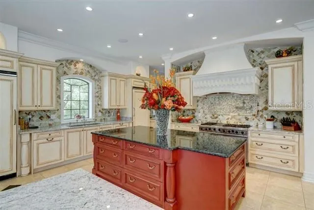 a view of a kitchen with white cabinets and a window