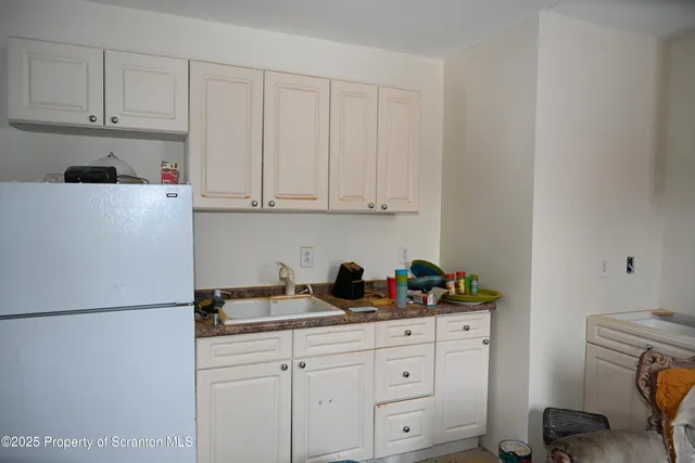 a kitchen with white cabinets and white appliances