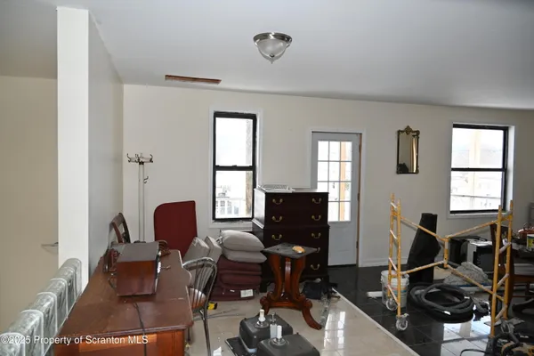 a living room with furniture chess board and a window