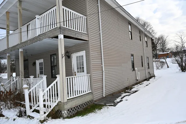 a view of a house with a small yard and wooden floor and fence