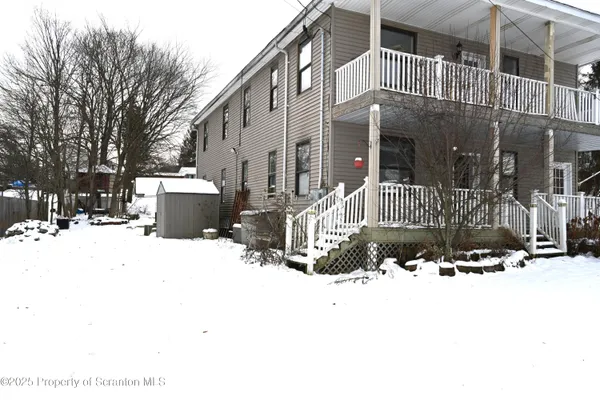 a view of building with a covered with snow in front of house
