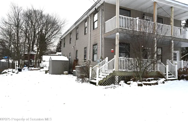 a view of building with a covered with snow in front of house