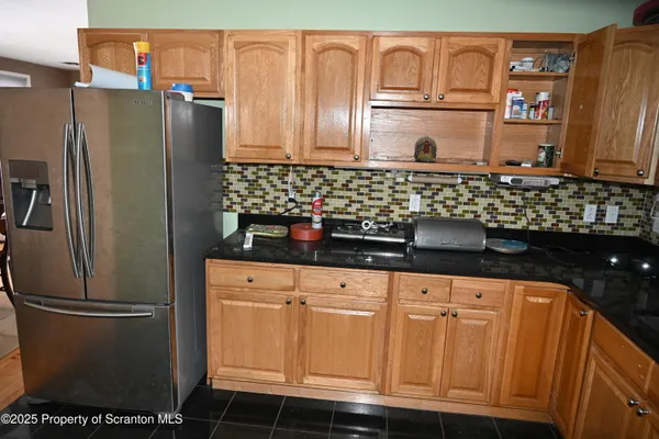 a kitchen with stainless steel appliances granite countertop a refrigerator and a sink