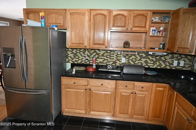 a kitchen with stainless steel appliances granite countertop a refrigerator and a sink