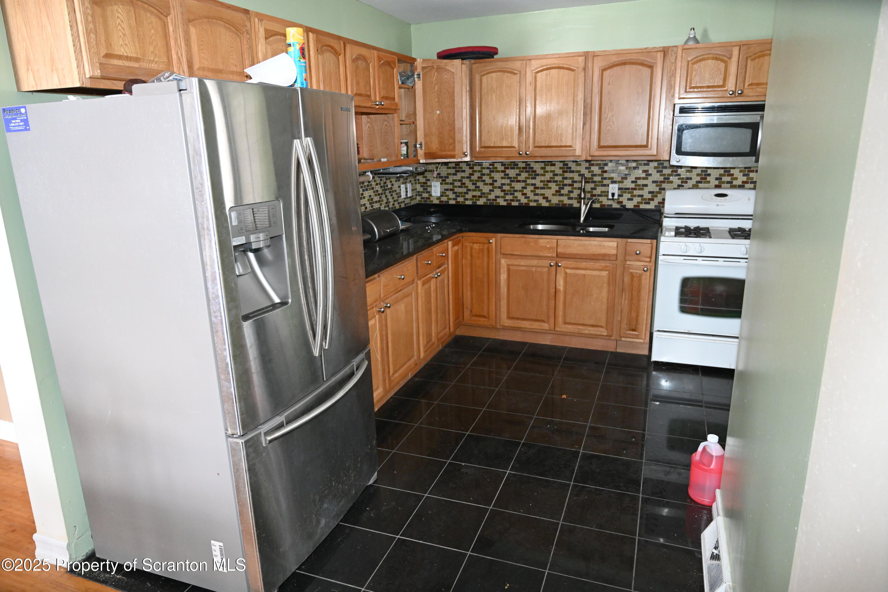 93 Prospect Street Hallstead, PA 18822 - Photo 6 of 32 a kitchen with granite countertop a refrigerator and a stove