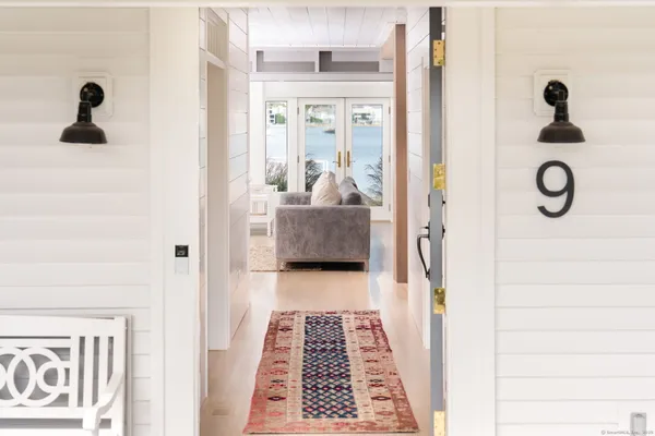 a hallway view with wooden floor and windows