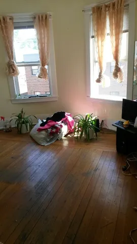 a view of a room with wooden floor and window