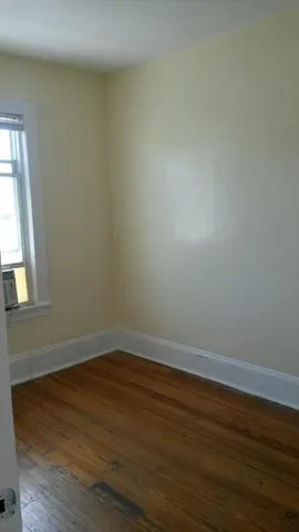 a room with wooden floor and windows