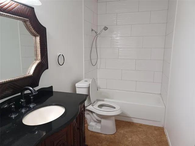 a bathroom with a toilet sink vanity shower and mirror