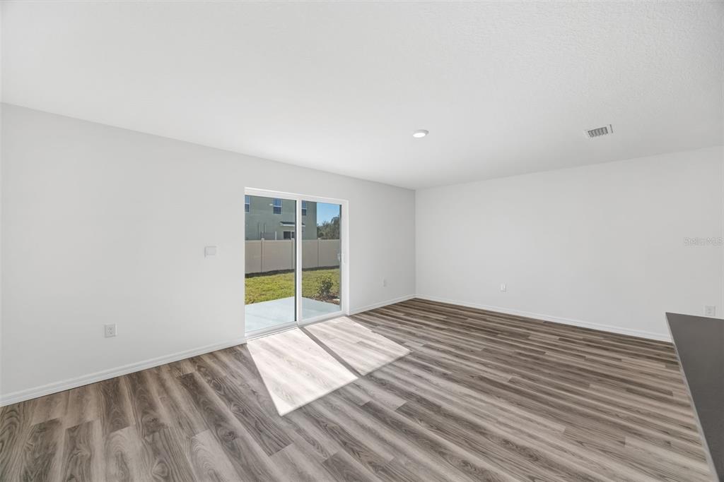 1009 Spotted Egret Loop Ruskin, FL 33570 - Photo 13 of 33 a view of an empty room with wooden floor and a window