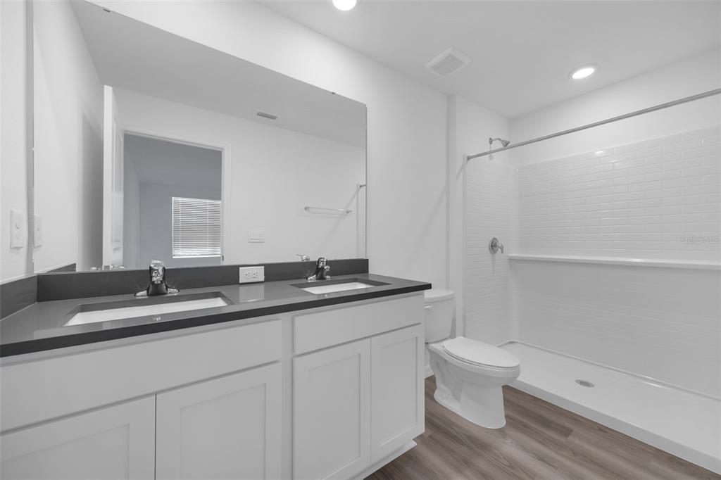 1009 Spotted Egret Loop Ruskin, FL 33570 - Photo 20 of 33 a bathroom with a granite countertop sink a toilet and a mirror