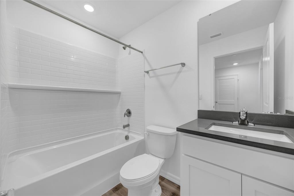 1009 Spotted Egret Loop Ruskin, FL 33570 - Photo 23 of 33 a bathroom with a granite countertop sink a toilet and bathtub