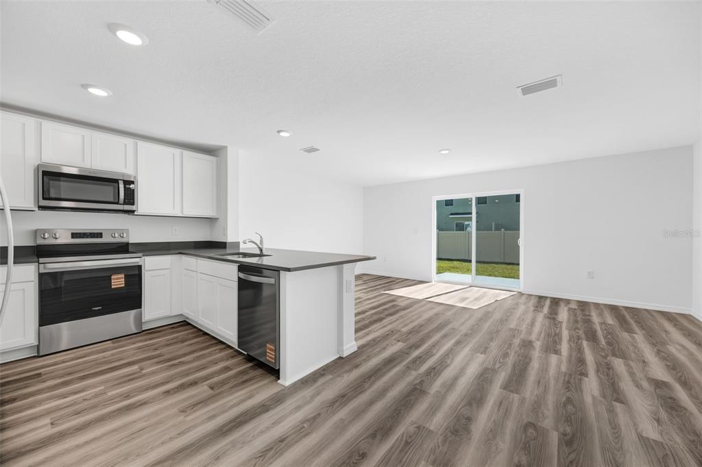 1009 Spotted Egret Loop Ruskin, FL 33570 - Photo 5 of 33 a kitchen with granite countertop a stove top oven and cabinets