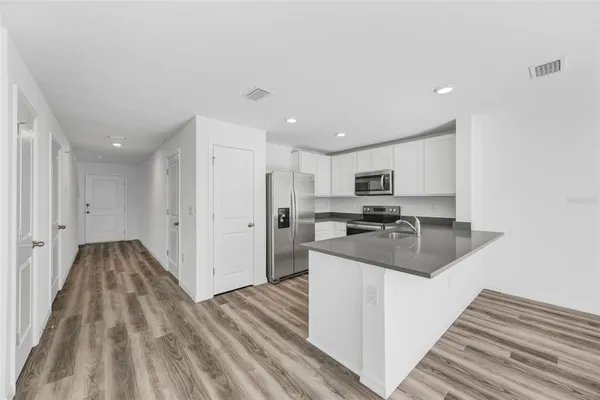 a kitchen with kitchen island sink and living room