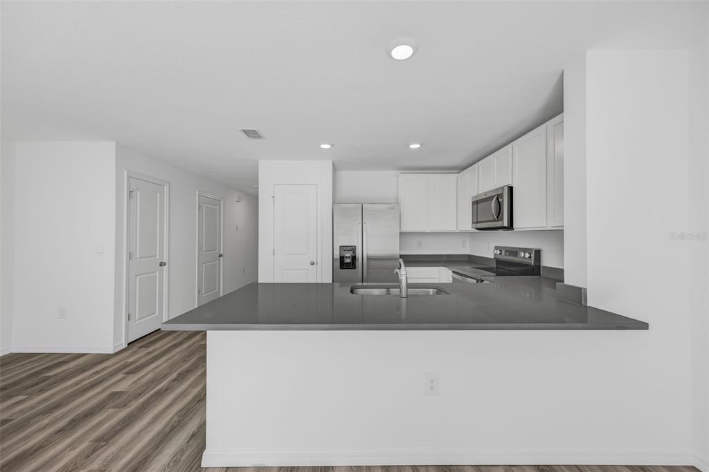 1009 Spotted Egret Loop Ruskin, FL 33570 - Photo 8 of 33 a kitchen with kitchen island sink and living room