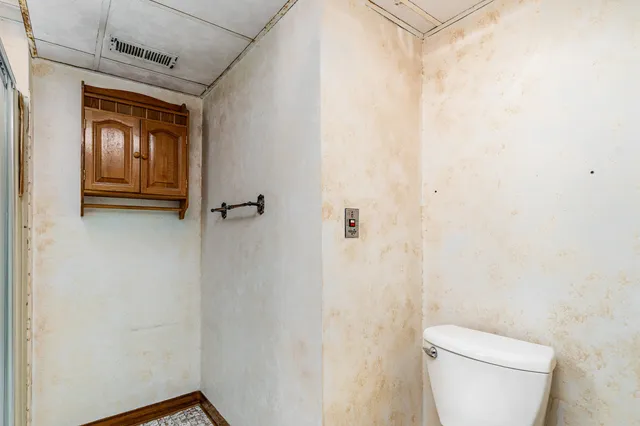 a bathroom with a toilet and a shower