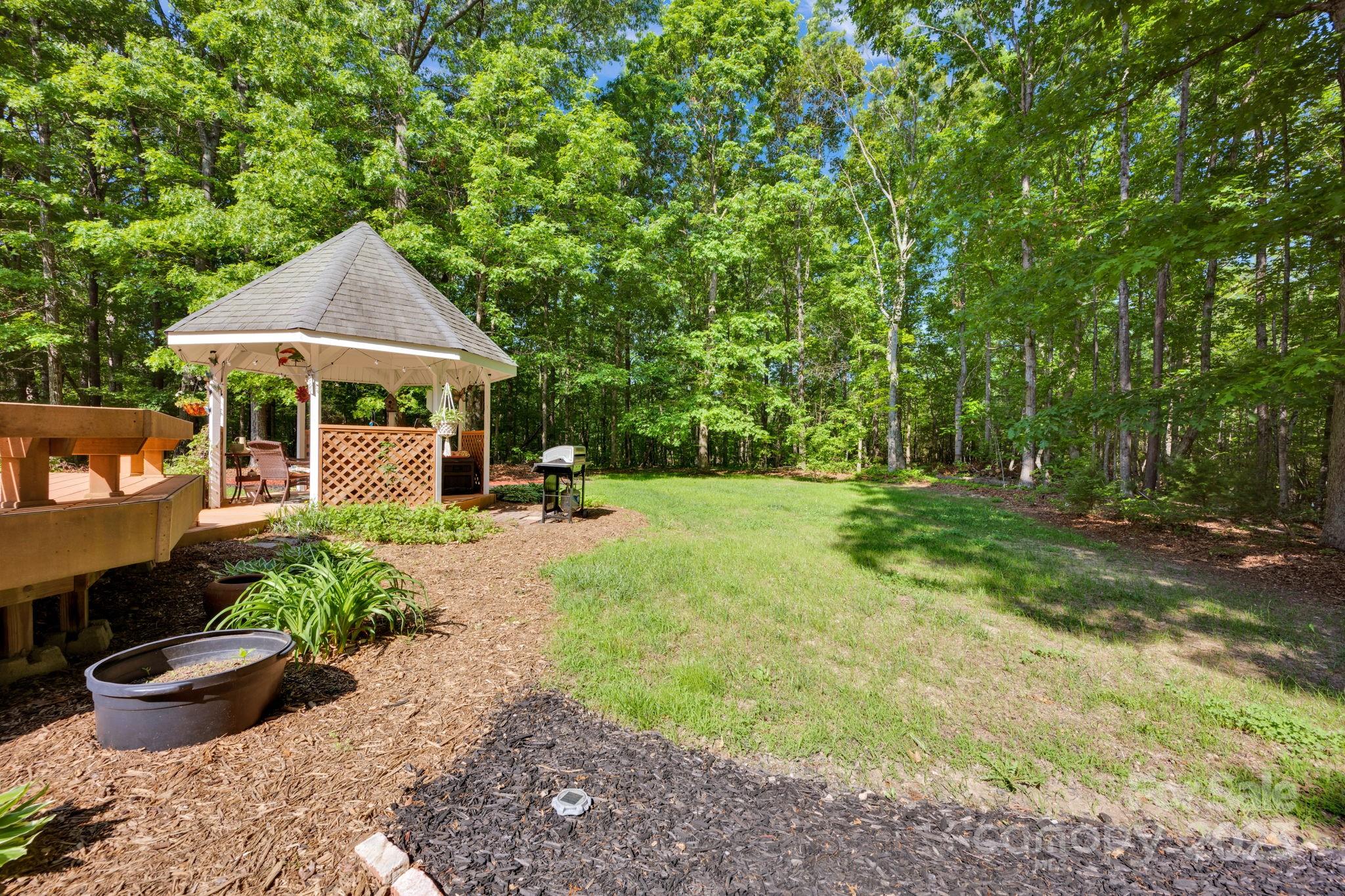 3610 Providence Mill Road Maiden, NC 28650 - Photo 37 of 44 a view of a patio with table and chairs potted plants and large tree
