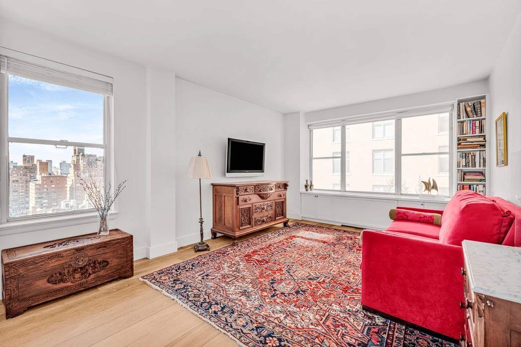 169 East 69th Street, Unit 19A Manhattan, NY 10021 - Photo 7 of 13 a living room with furniture and a flat screen tv