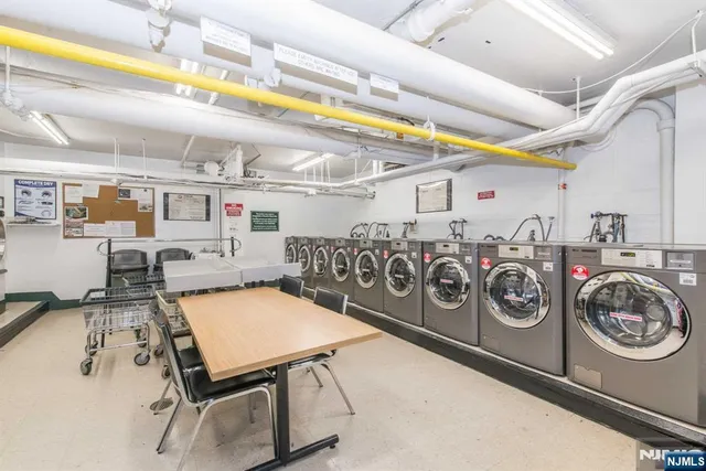 a utility room with stainless steel appliances lots of clutter
