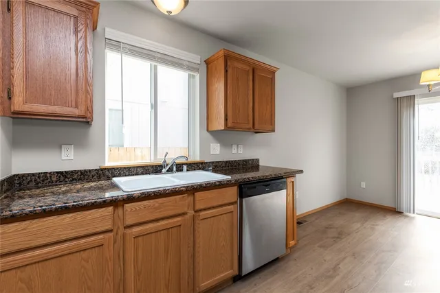 a kitchen with stainless steel appliances granite countertop a sink stove and cabinets