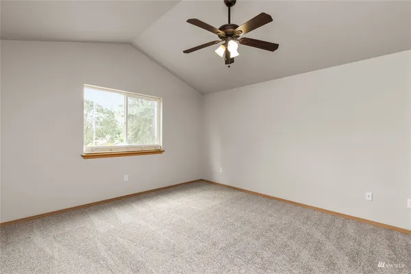 an empty room with closet and ceiling fan