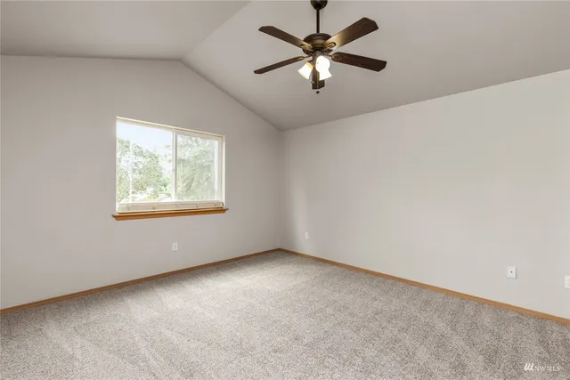 an empty room with closet and ceiling fan